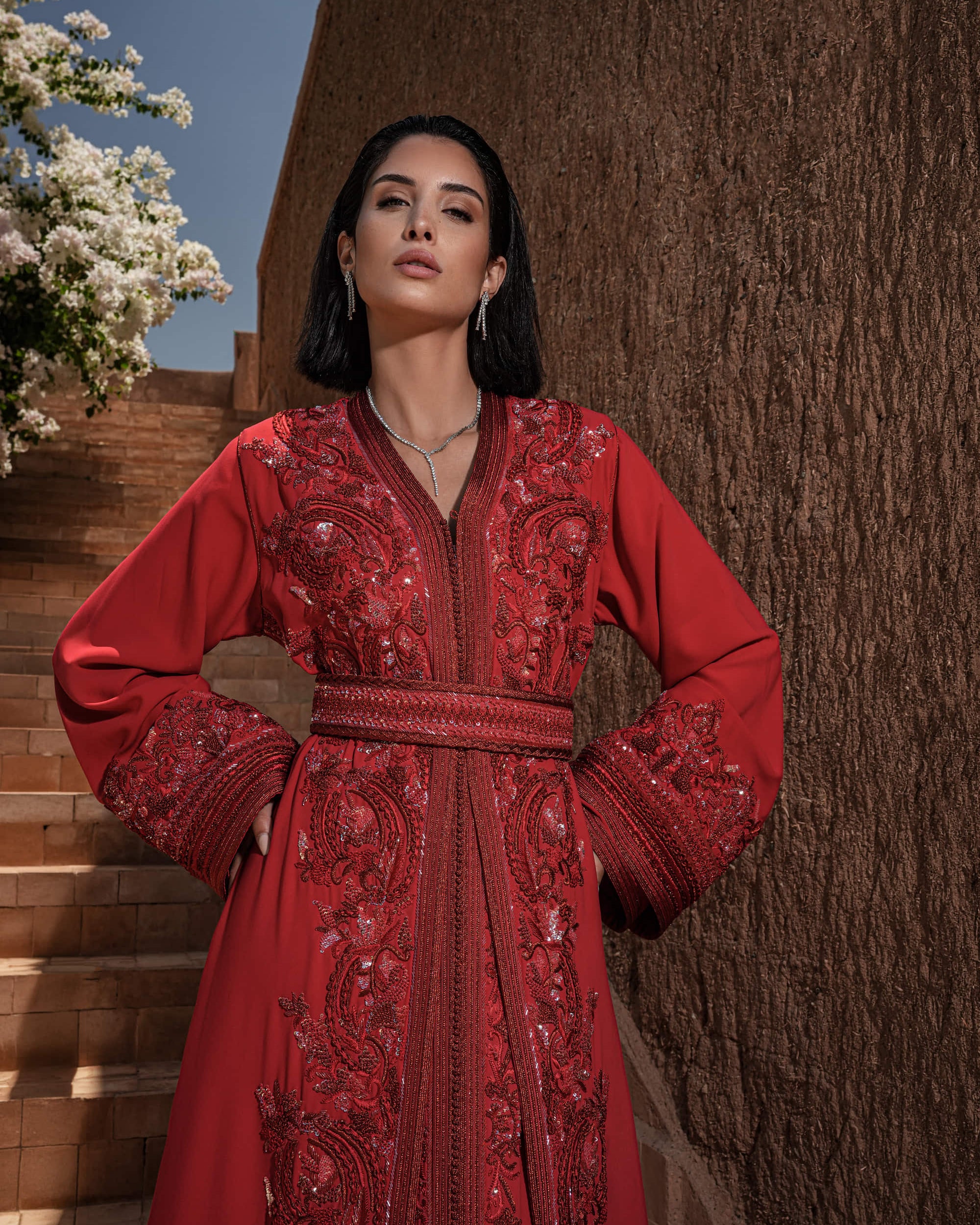 Carmine Cadence red crepe Moroccan kaftan with sequined paisley embroidery, braided belt and flared sleeves
