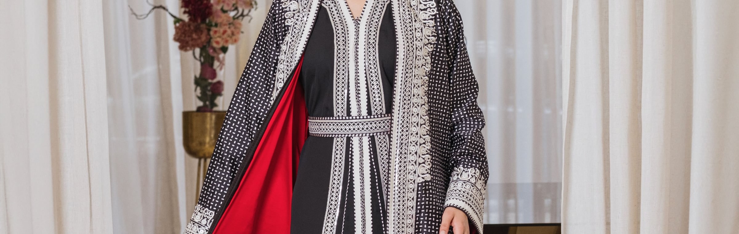 Black and white embroidered Moroccan kimono set worn over a red lining