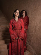 Carmine Cadence red crepe Moroccan kaftan with sequined paisley embroidery, braided belt and flared sleeves, shown alongside a second look